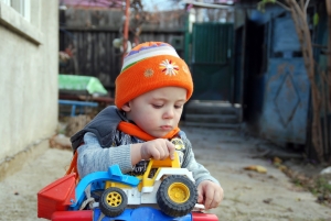 niño con coche de juguete